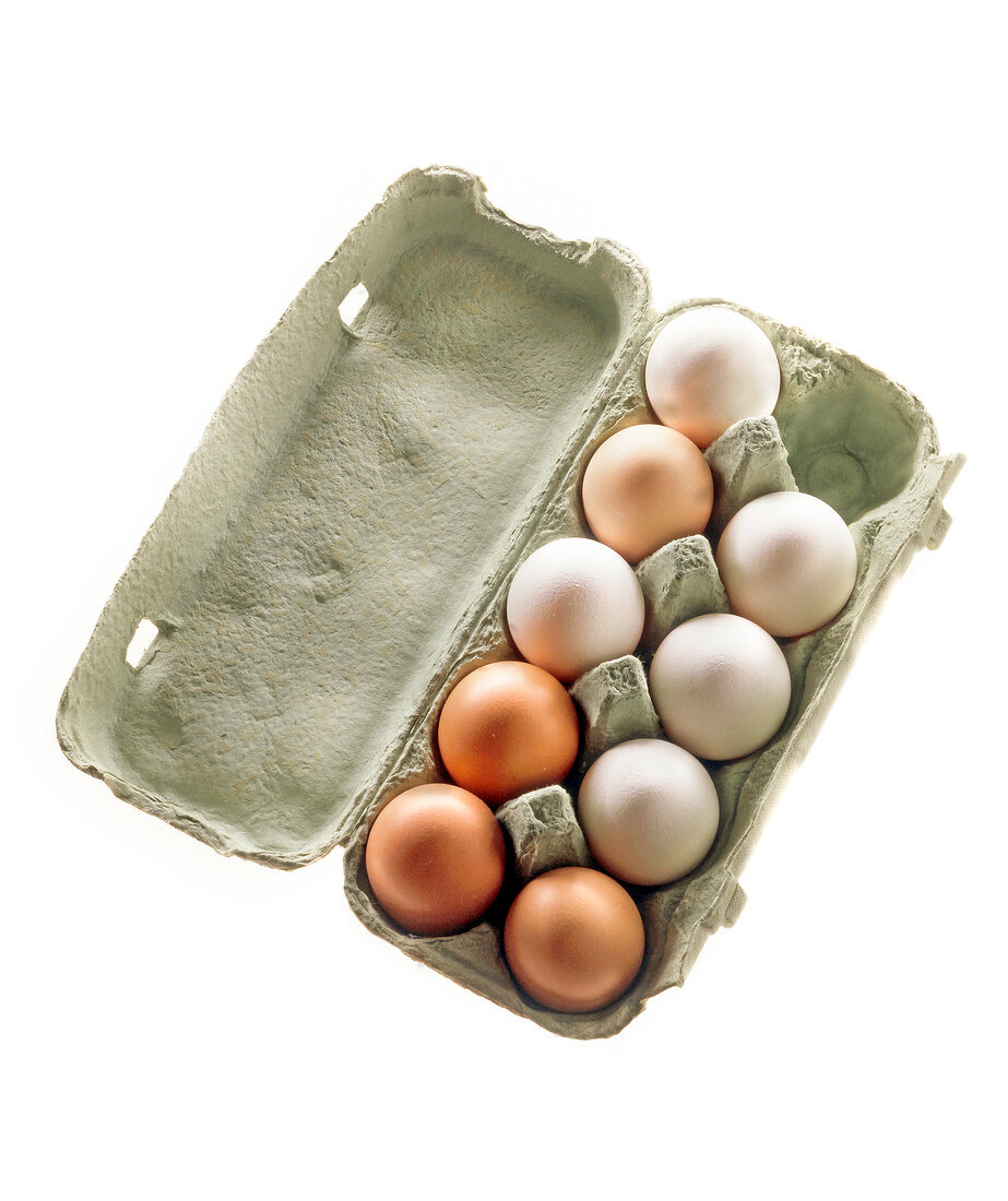 White and brown eggs in an open egg box on white background