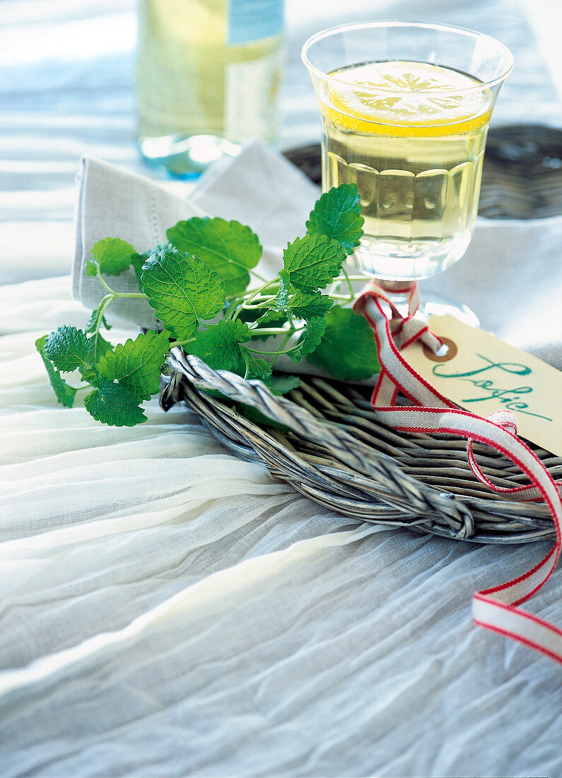 Close-up of mesh tray, welcome drink with nameplate and lemon juice