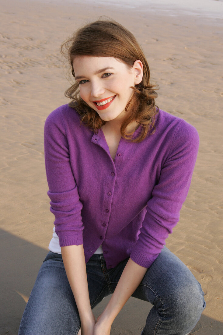 Janine Frau hockend am Strand