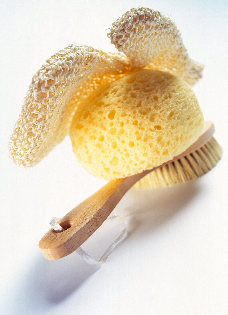 Close-up of bathing accessories brush sponge glove on white background