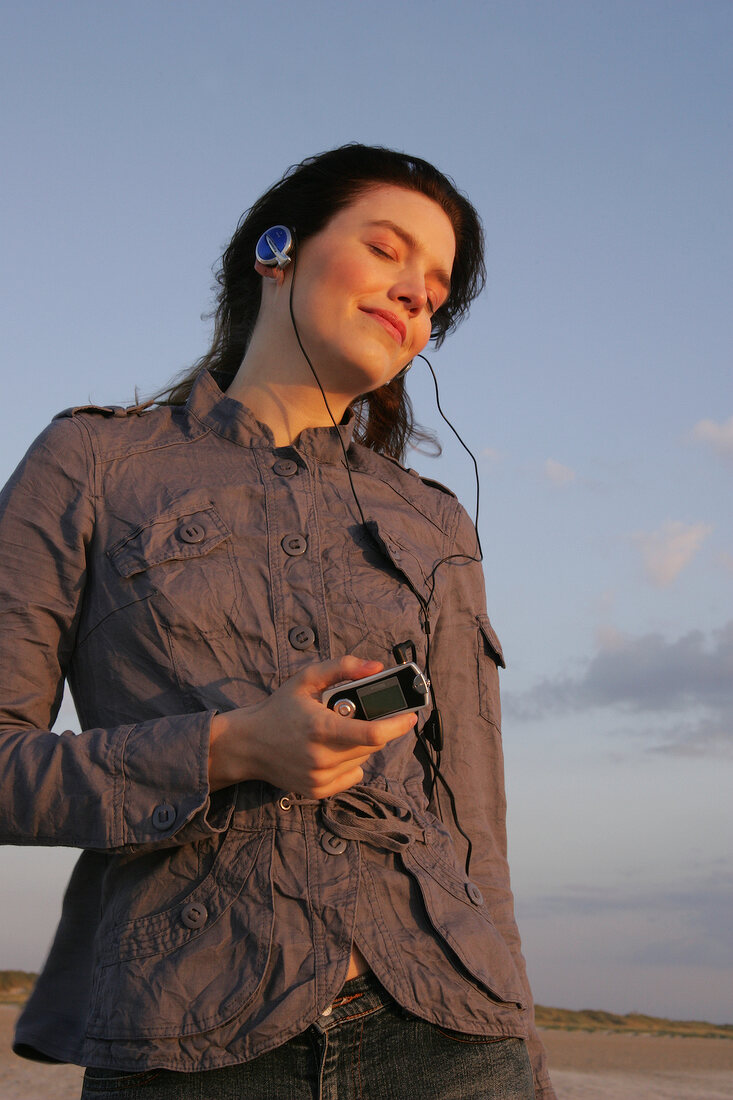 Janine Frau hört am Strand Musik