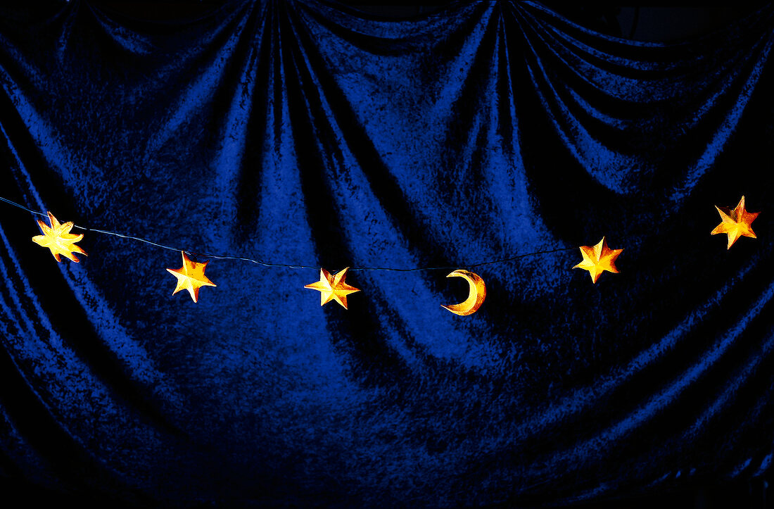 Lichterkette in Form von  Halbmond, Sternen, Hintergrund blau.