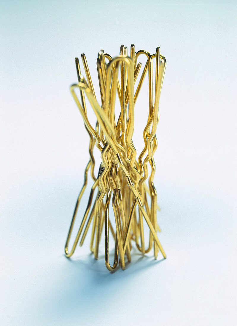 Close-up of golden hairpins arranged on white background