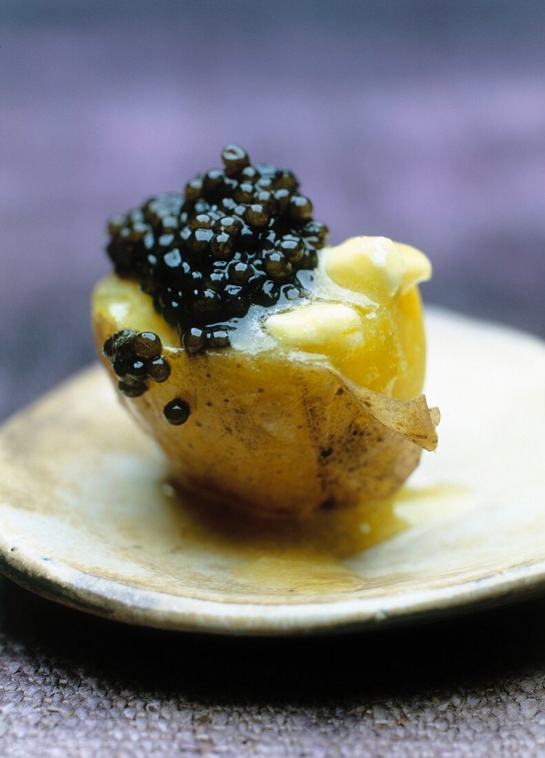 A new potato with caviar on an old-fashioned plate