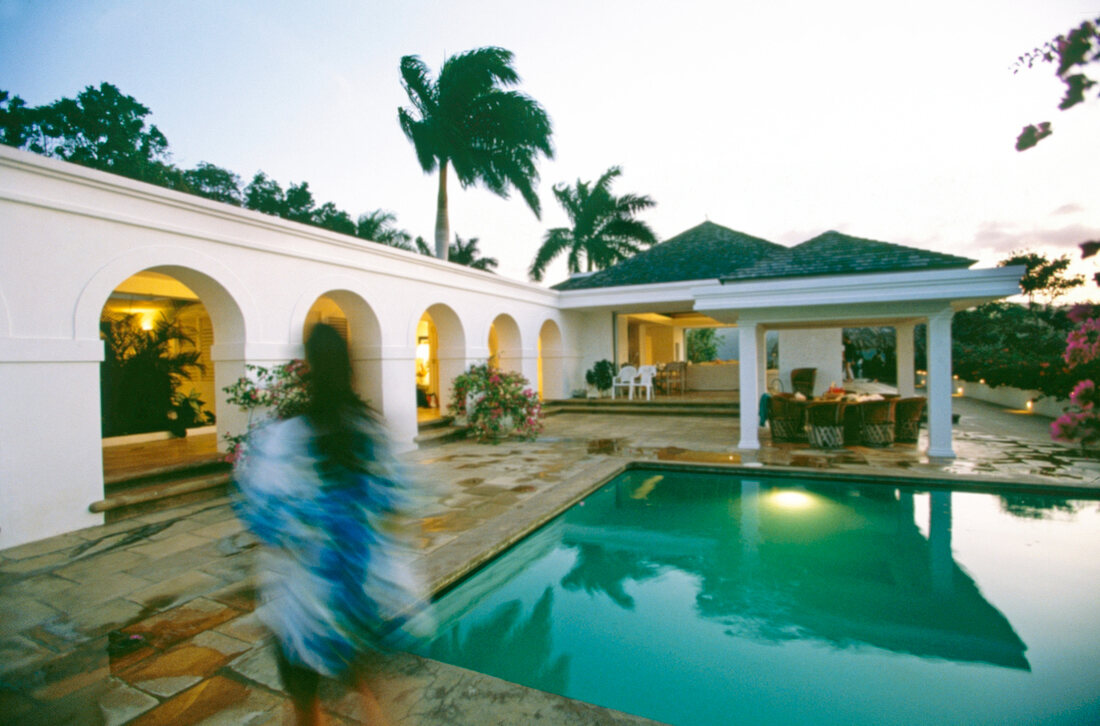 Vies of illuminated villa with pool and palm trees at dawn, Jamaica, Blurred motion