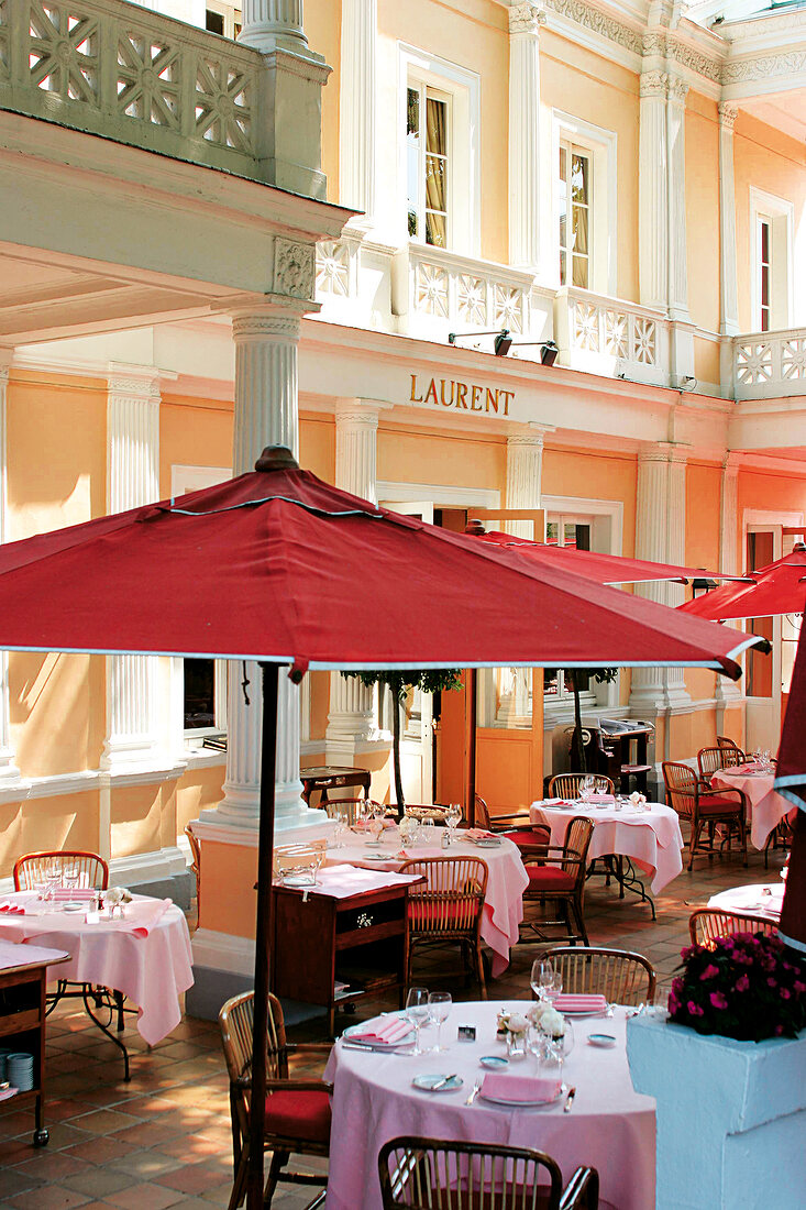 Laid tables and sunshades on terrace in Laurent restaurant, Paris, France