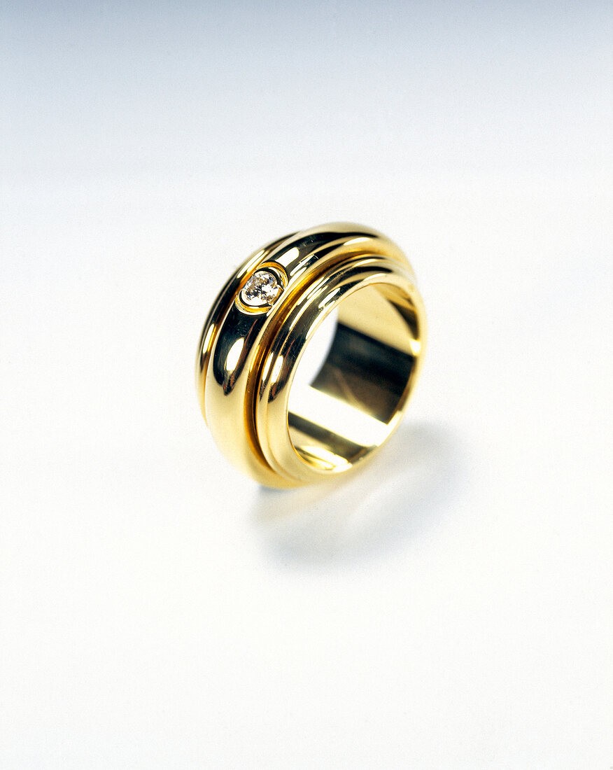 Close-up of golden diamond ring on white background