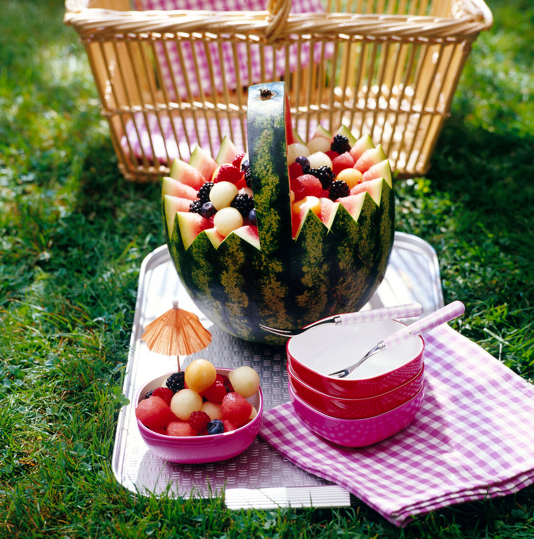 Melone zum Obstkorb geschnitten mit Beeren gefüllt, Schälchen