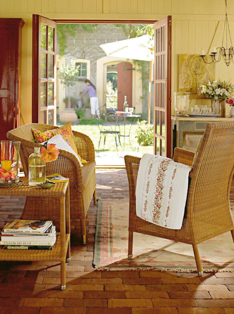 Living room with wicker furniture overlooking courtyard through door