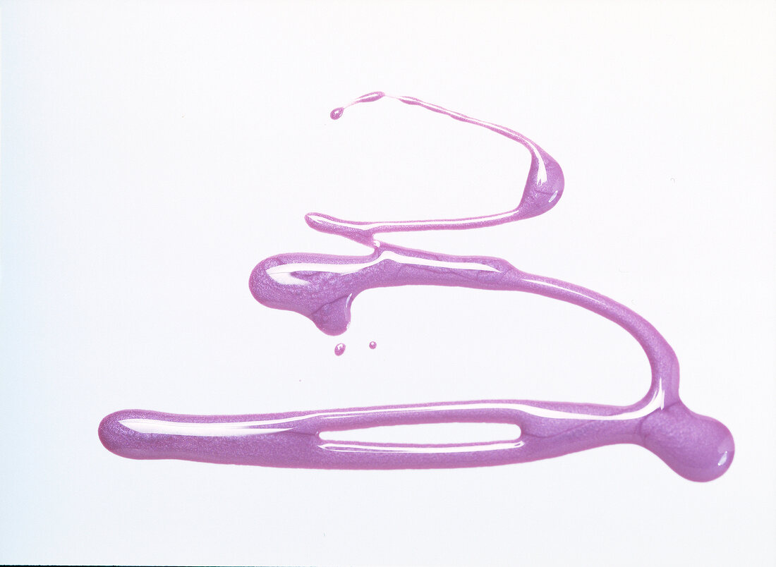 Close-up of purple nail paint on white background