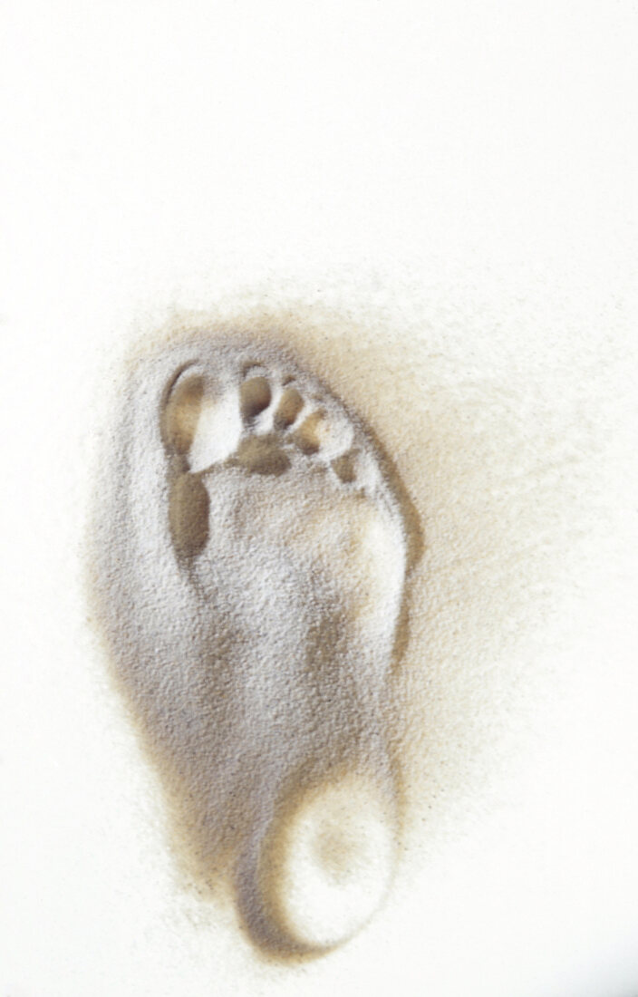 Footprint of a man on white sand