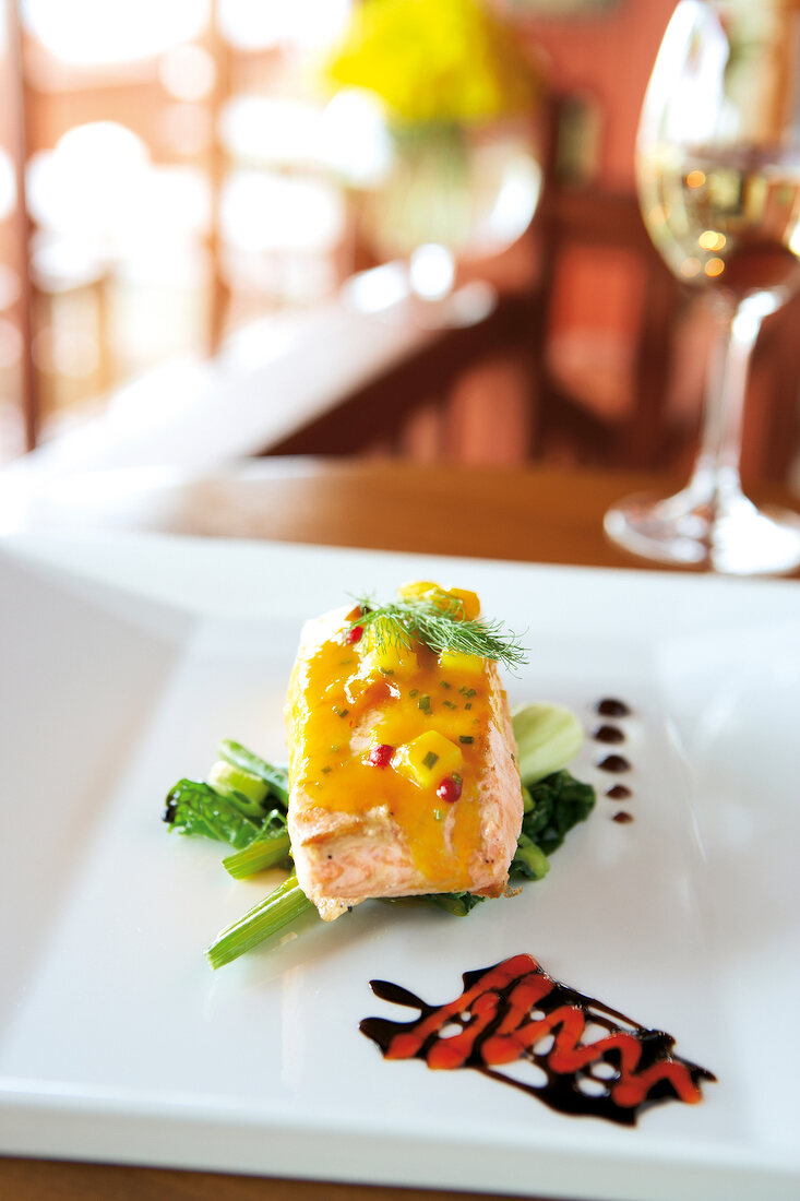 Close-up of salmon with mango sauce on plate