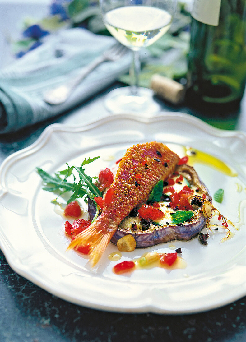 Fried red mullet with eggplant served on plate