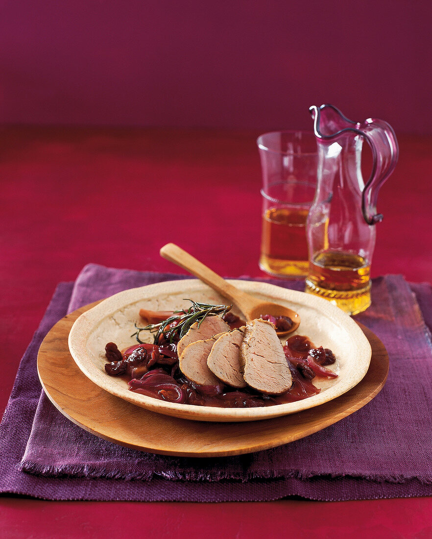 Pork with cherry sauce served on plate