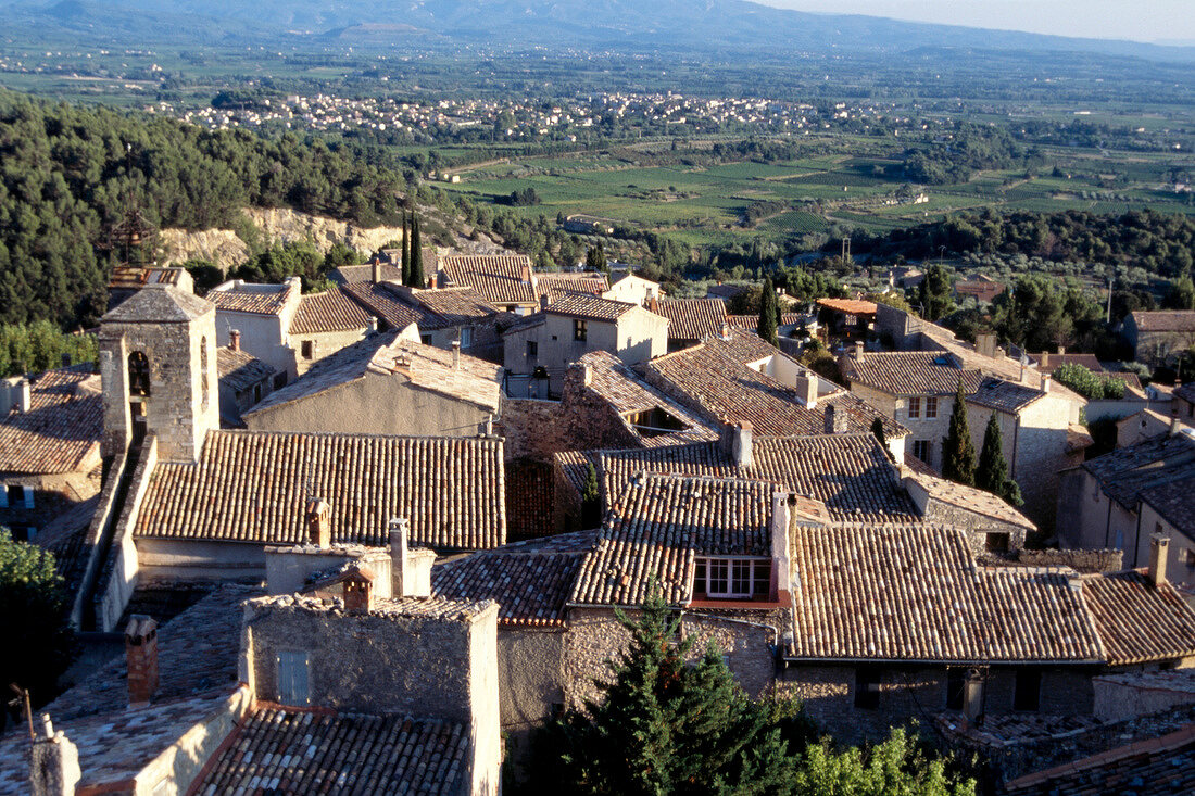 View of house roof tops, mountains and fields
