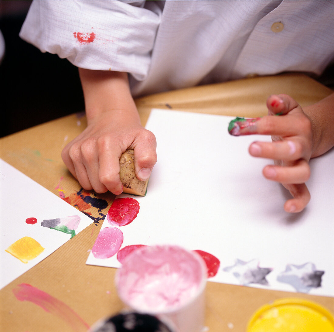 Child stamping on paper with homemade potato stamp