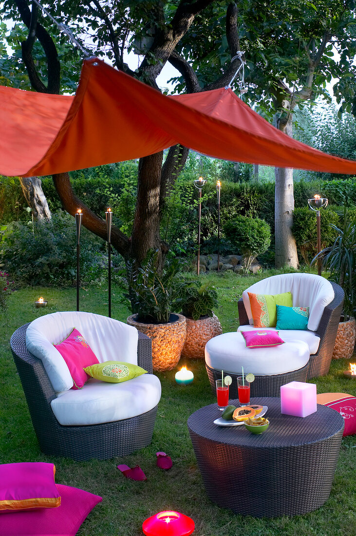 Sofa with cushions in colourful sitting area in garden for party