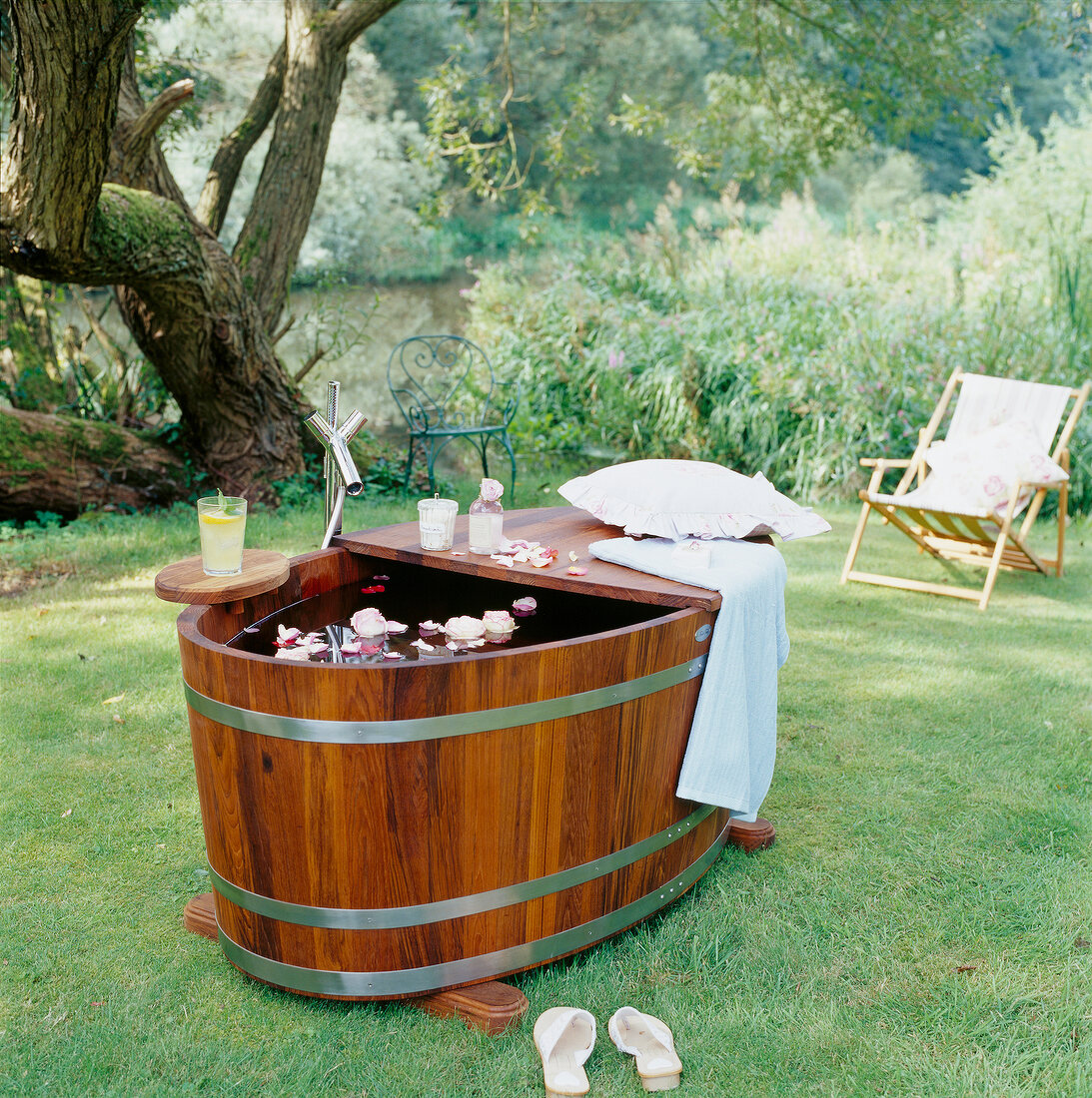 Wooden tub with floating flowers in the garden