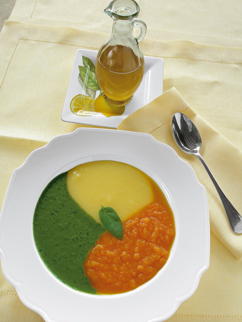 Suppe in Gelb, Grün und Orange aus Karotten, Kartoffeln und Basilikum