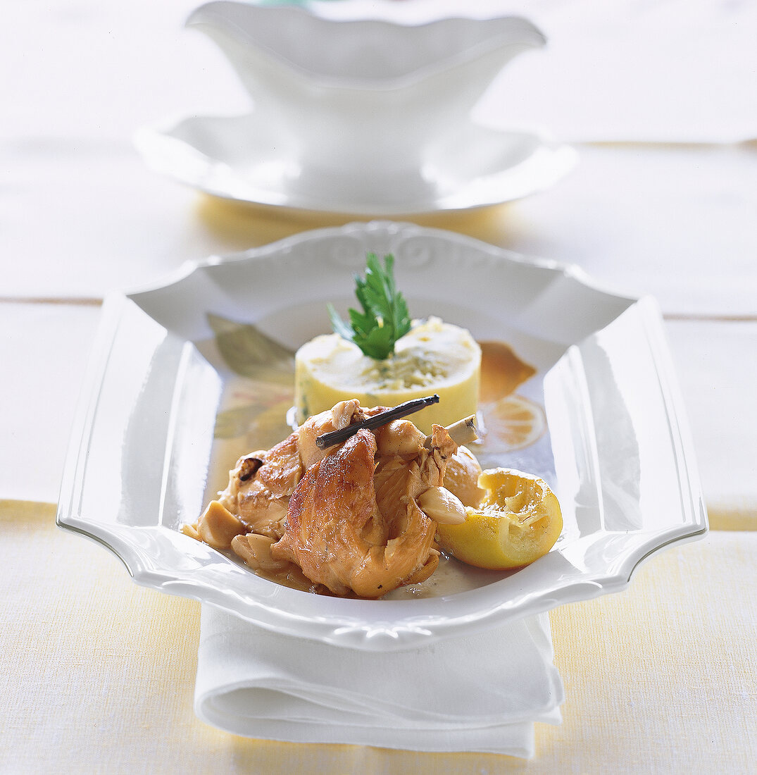 Roasted rabbit with lemon, garlic, white wine and vanilla in white serving plate