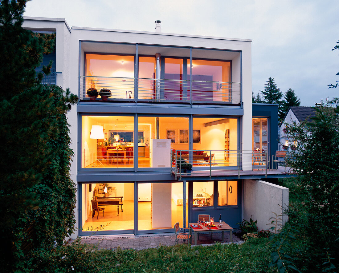 Wohnhaus mit drei Etagen beleuchtet, große Fensterfronten