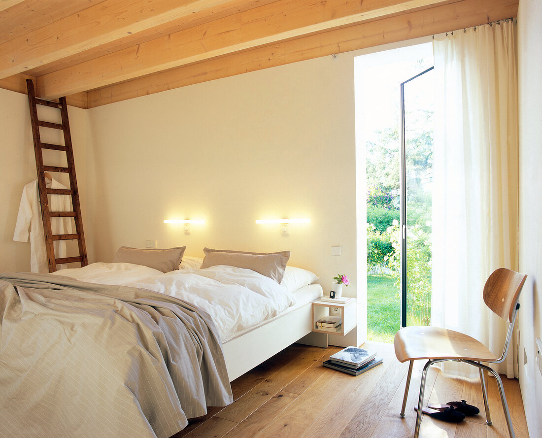 Room with sofa, chair, ladder, wooden ceiling and open patio door