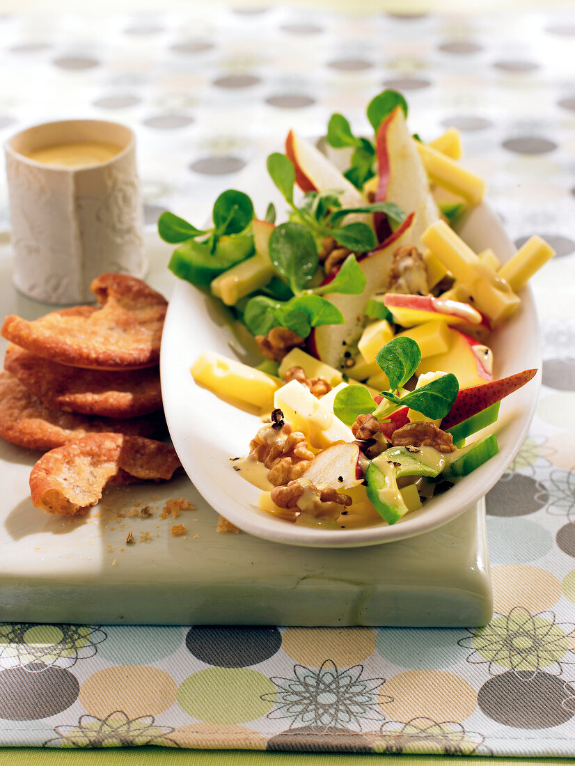 Apple salad marinated with cheese and walnuts on plate