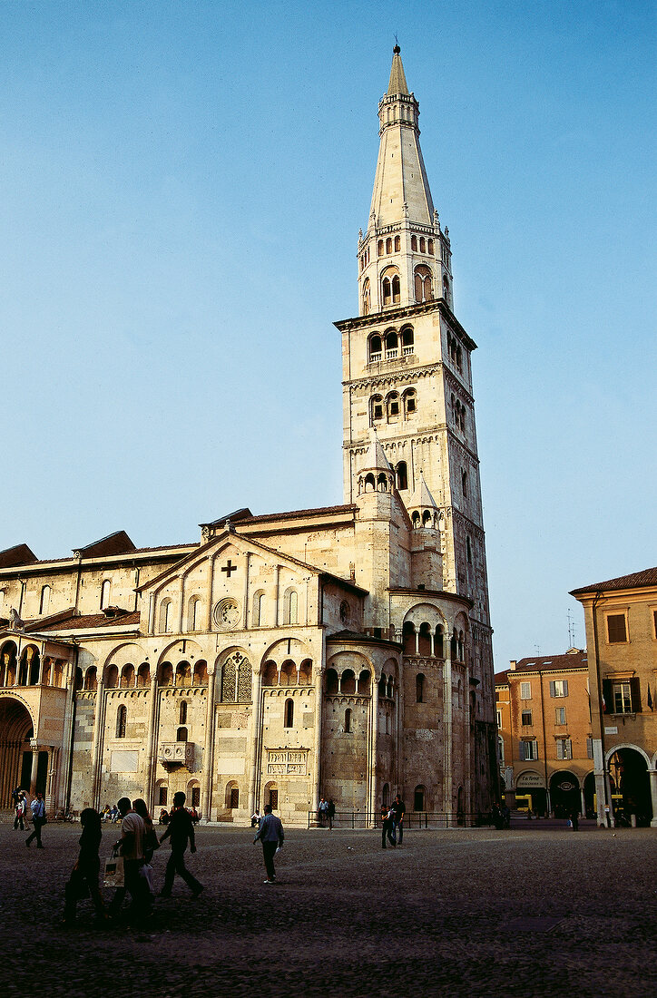 People walking in front of Romanesque cathedral, Modena, Italy