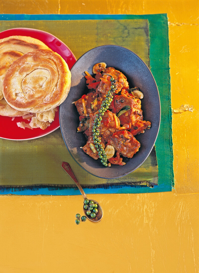 Spicy lamb with green pepper sauce and Kerala porotta on plate