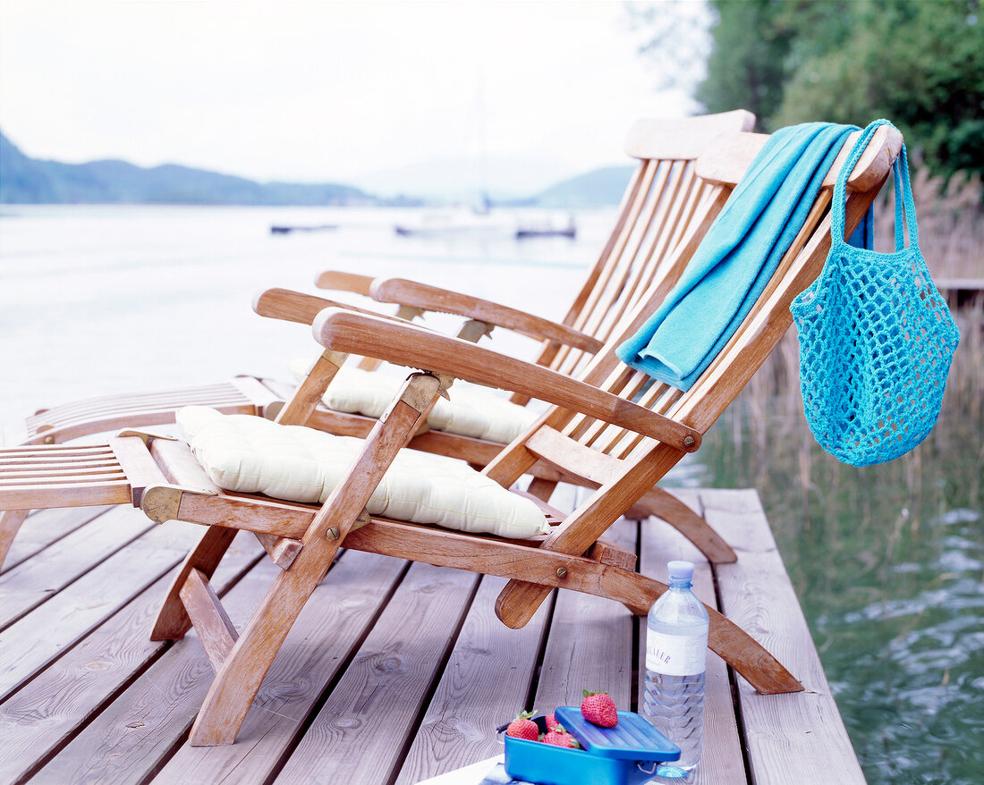 Two wooden loungers on waterfront