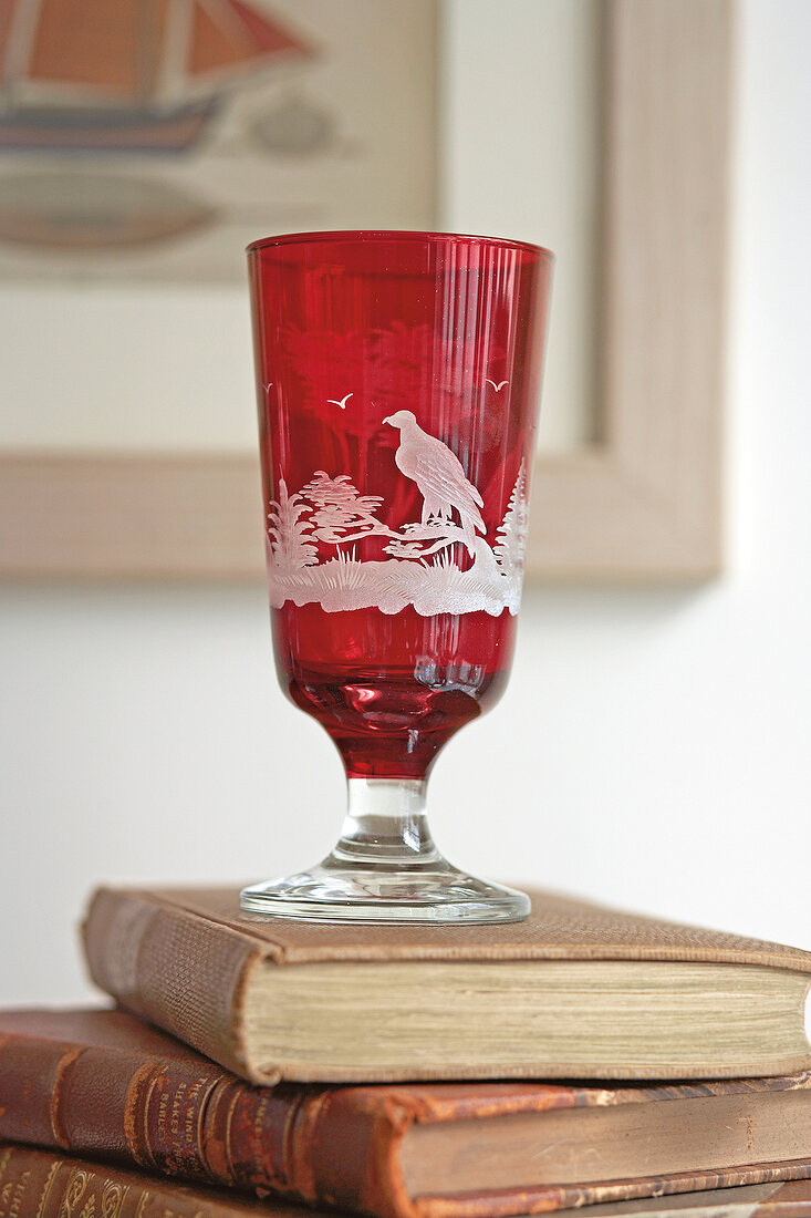Red crystal glass cup on stack of books