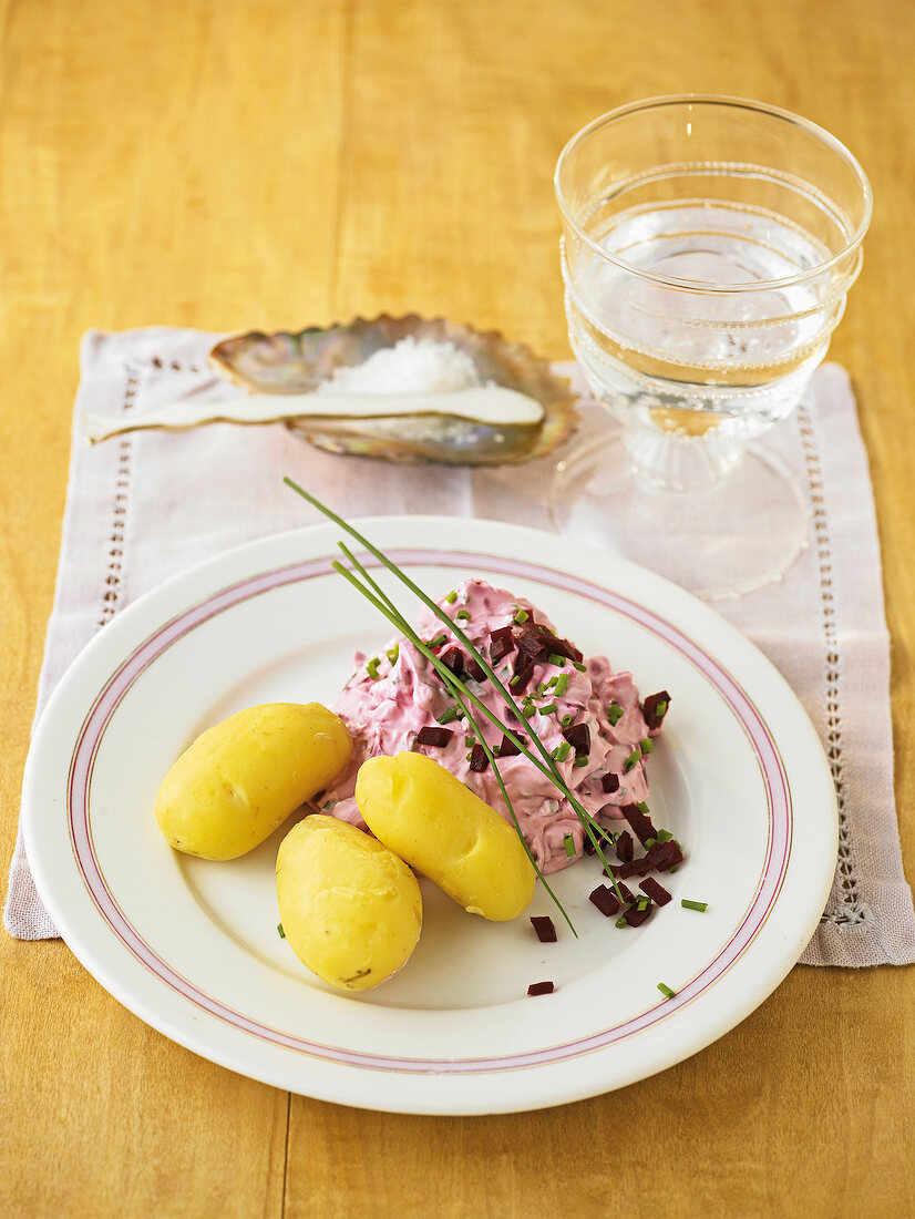 Boiled potatoes with beetroot quark and pieces on plate