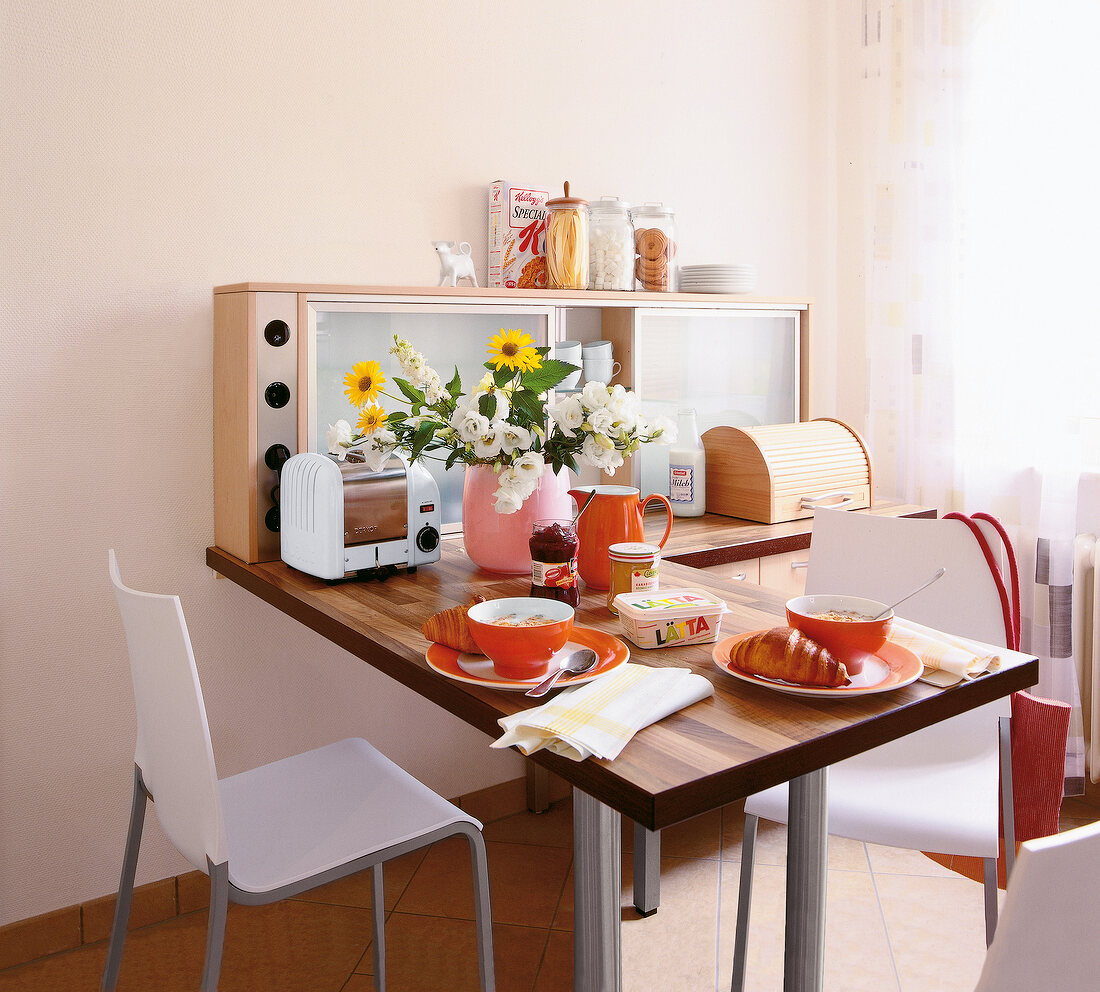 Niche cabinet with chairs, utensils on L shape laid table