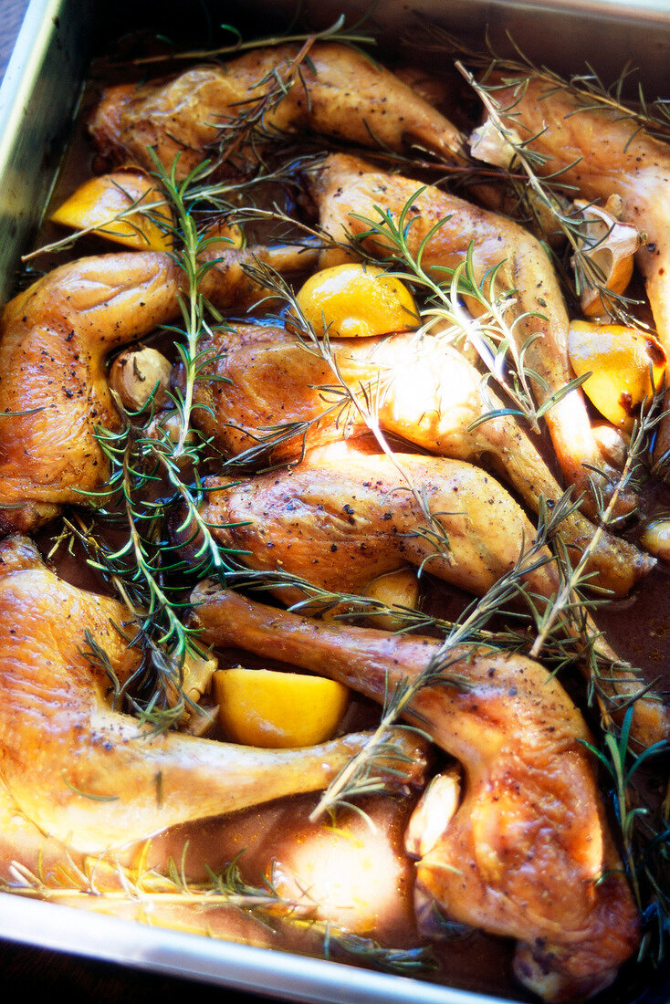 Zitronenhuhn mit Rosmarin und Kartoffeln im Bräter.