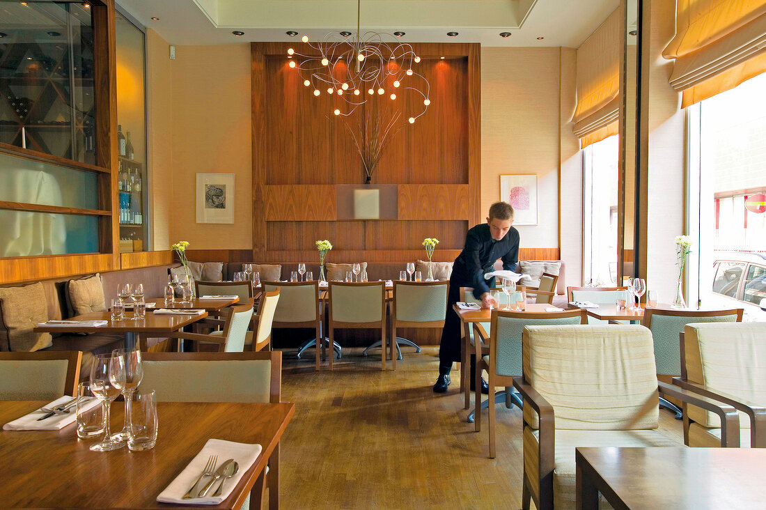 Waiter arranging table in Niklas restaurant, Stockholm, Sweden