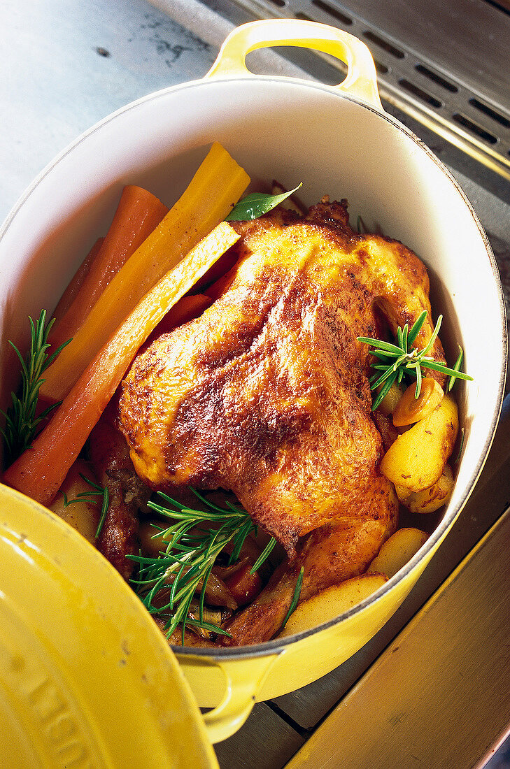 Simmered chicken with rosemary, carrots and potatoes in casserole