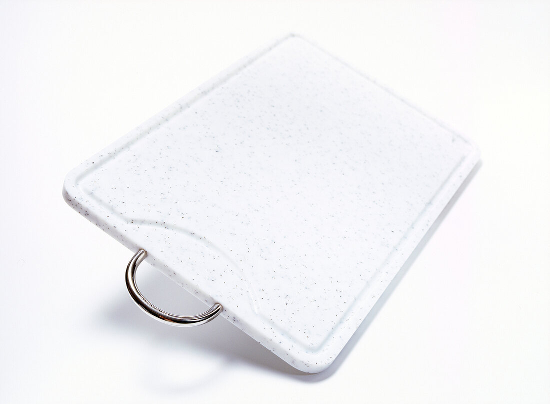 White chopping board in rectangle shape with metal handle on white background