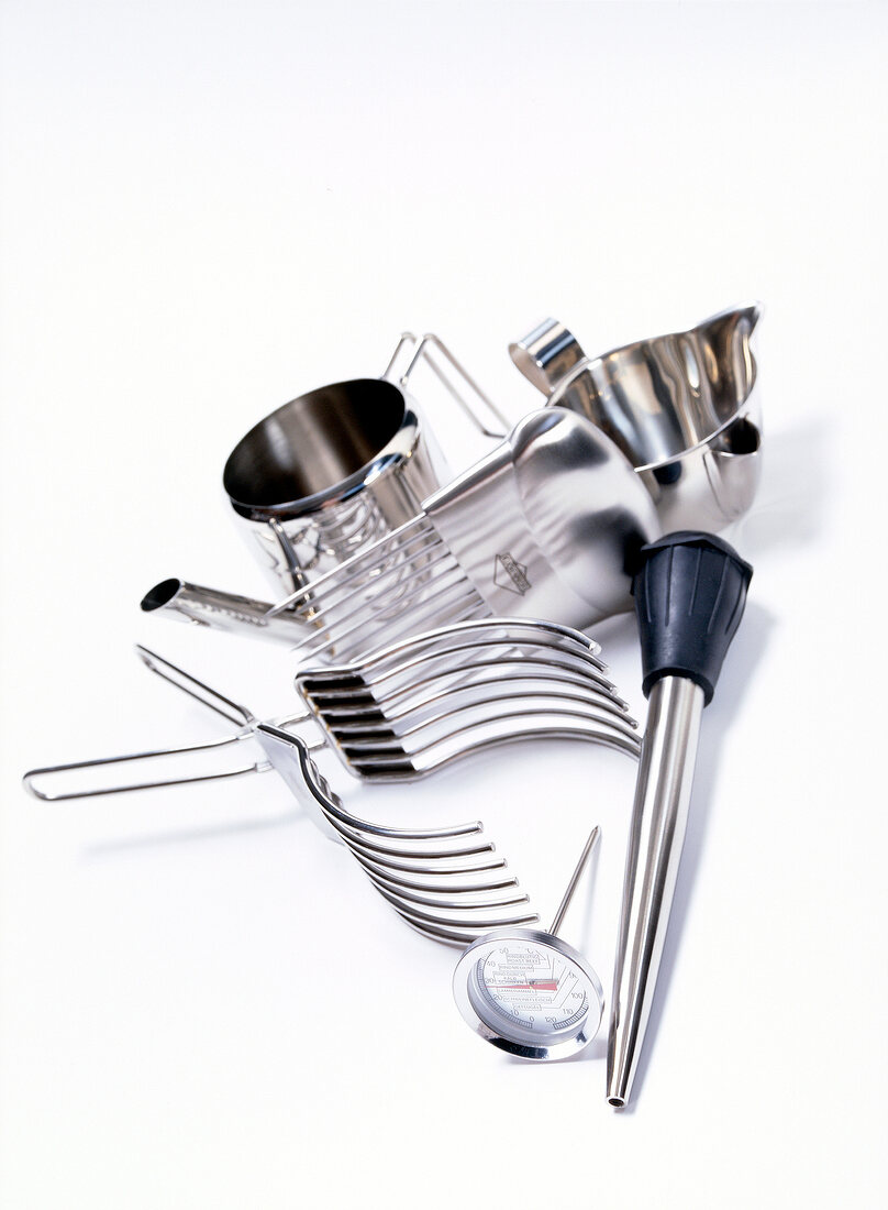 Different kitchen utensils of stainless steel on white background