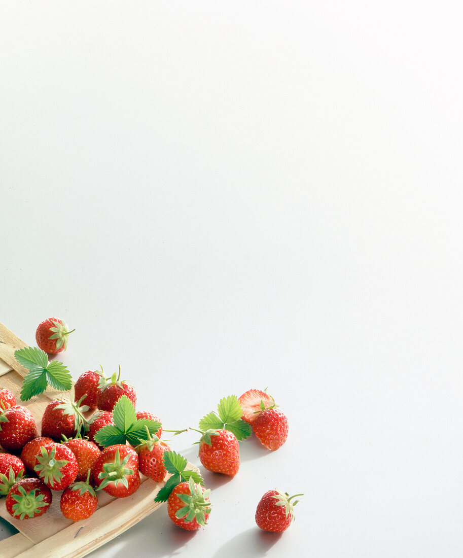 Strawberries on wooden board and on white background, copy space