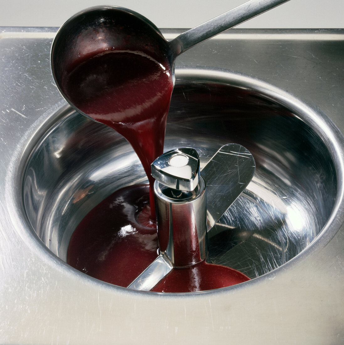 Close-up of fruit syrup being poured in stirrer