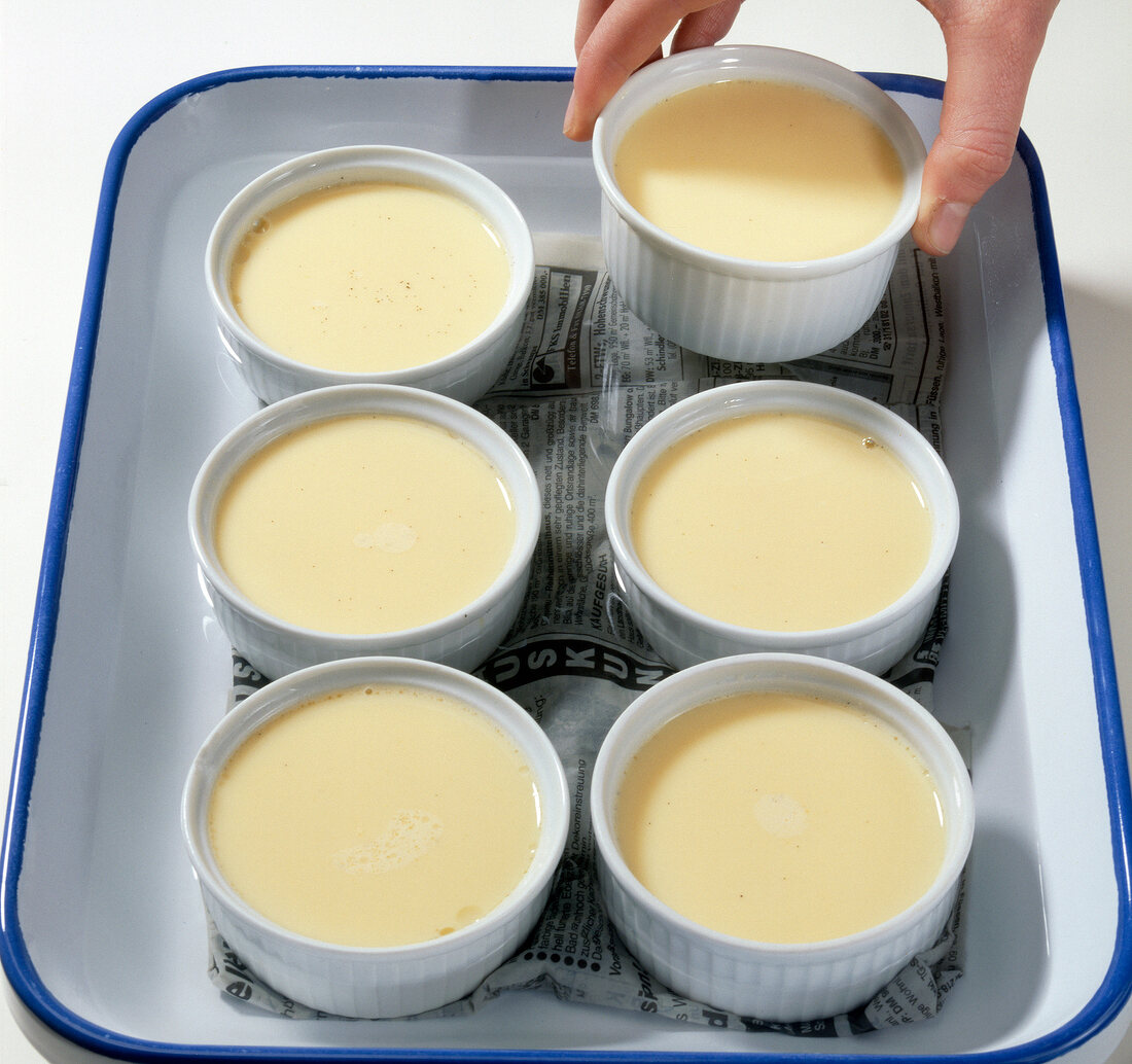 Ramekins with cream in hot water tray