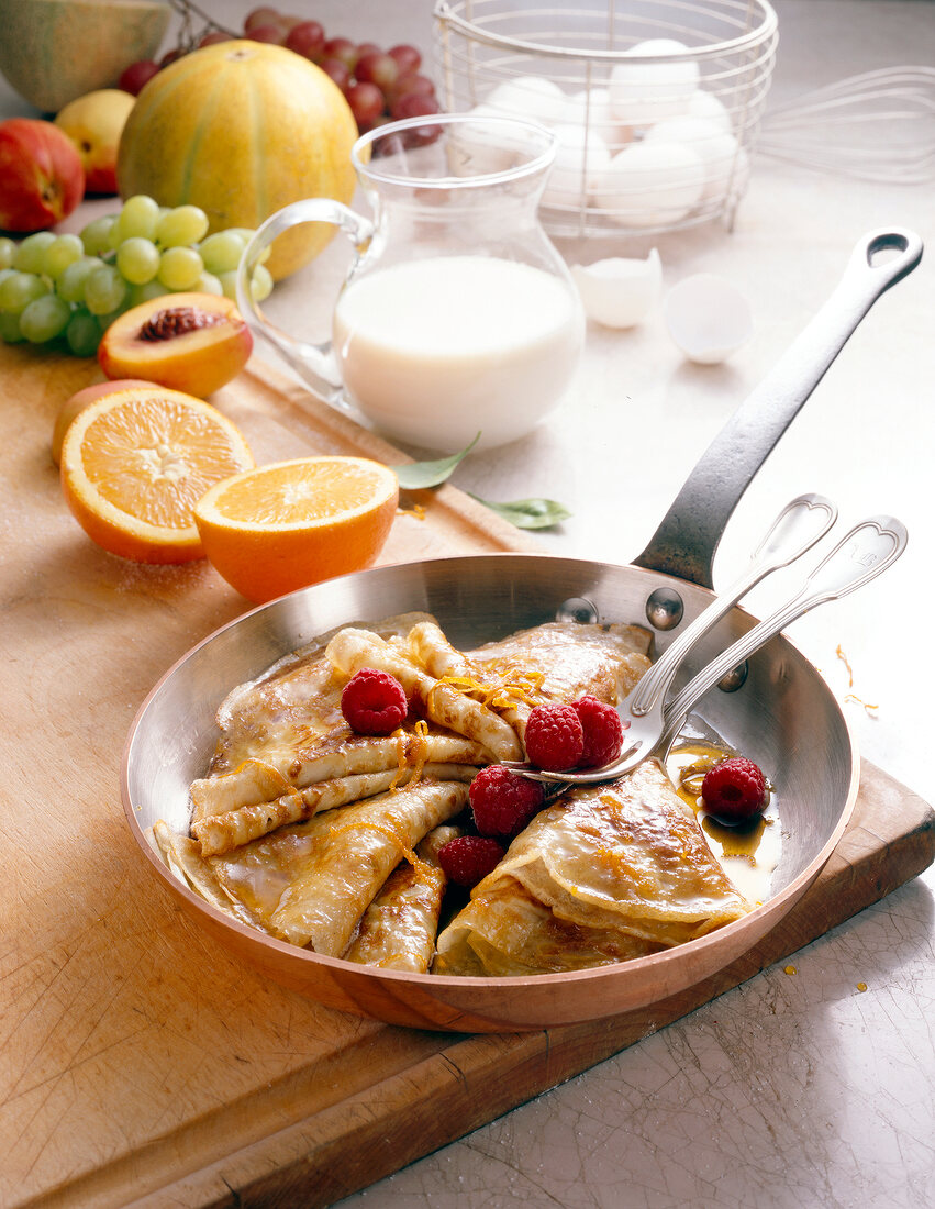 Crepe with raspberries and orange sauce in pan