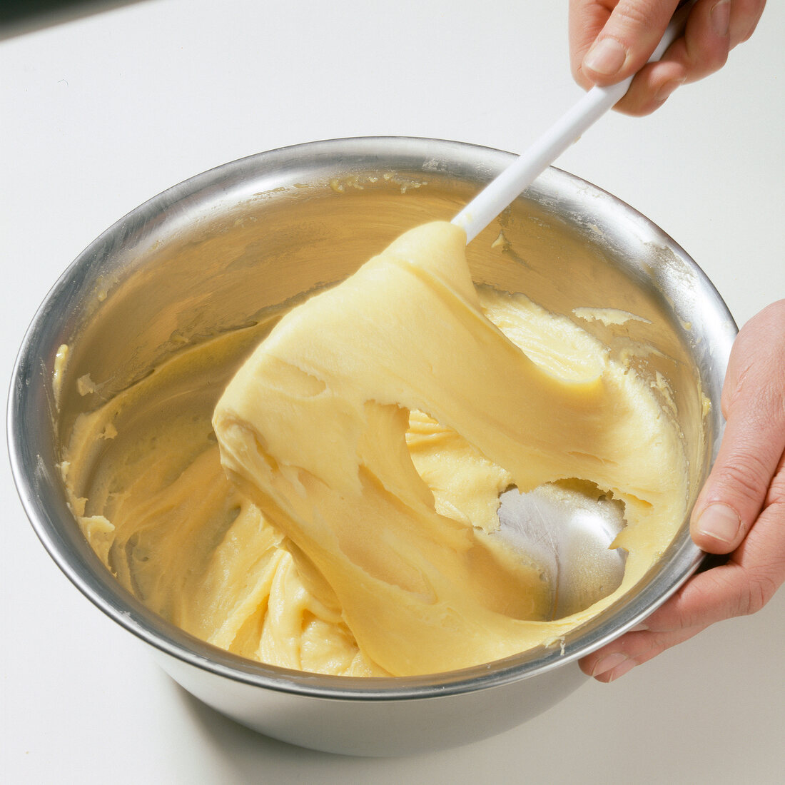 Hand mixing smooth dough in bowl