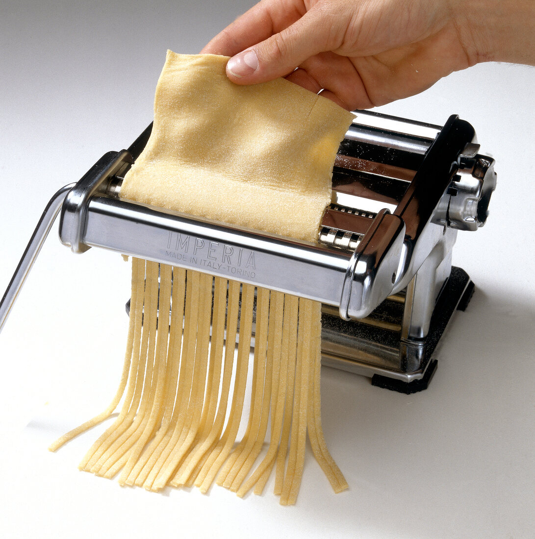 Pasta dough being sliced in pasta machine