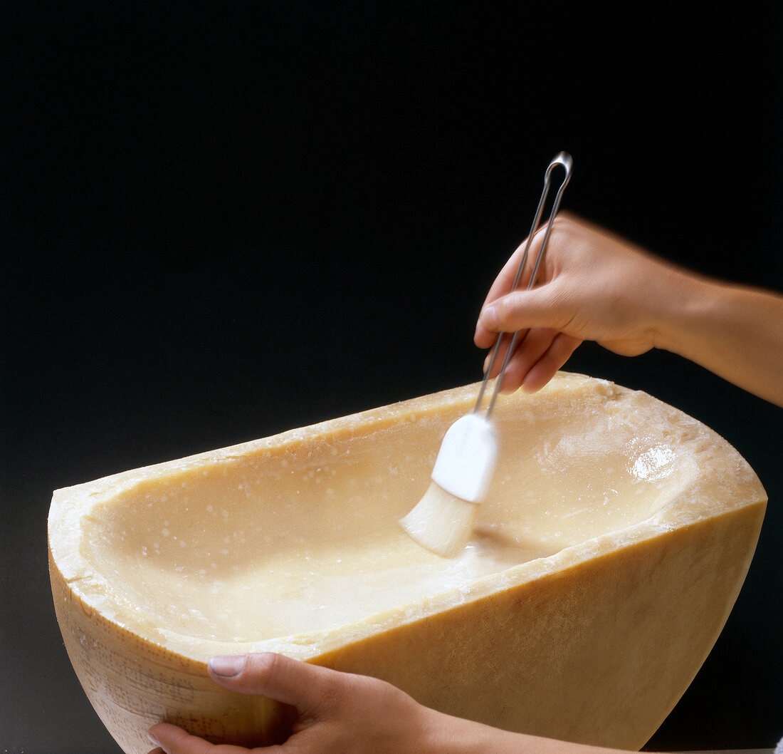 Hand greasing alcohol with brush in parmesan cheese, step 2
