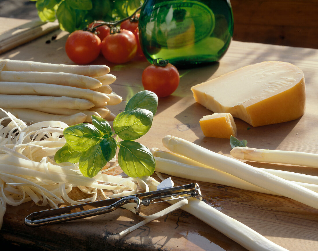 Nudeln aus aller Welt, Spargel Käse, Tomaten auf Holzuntergrund