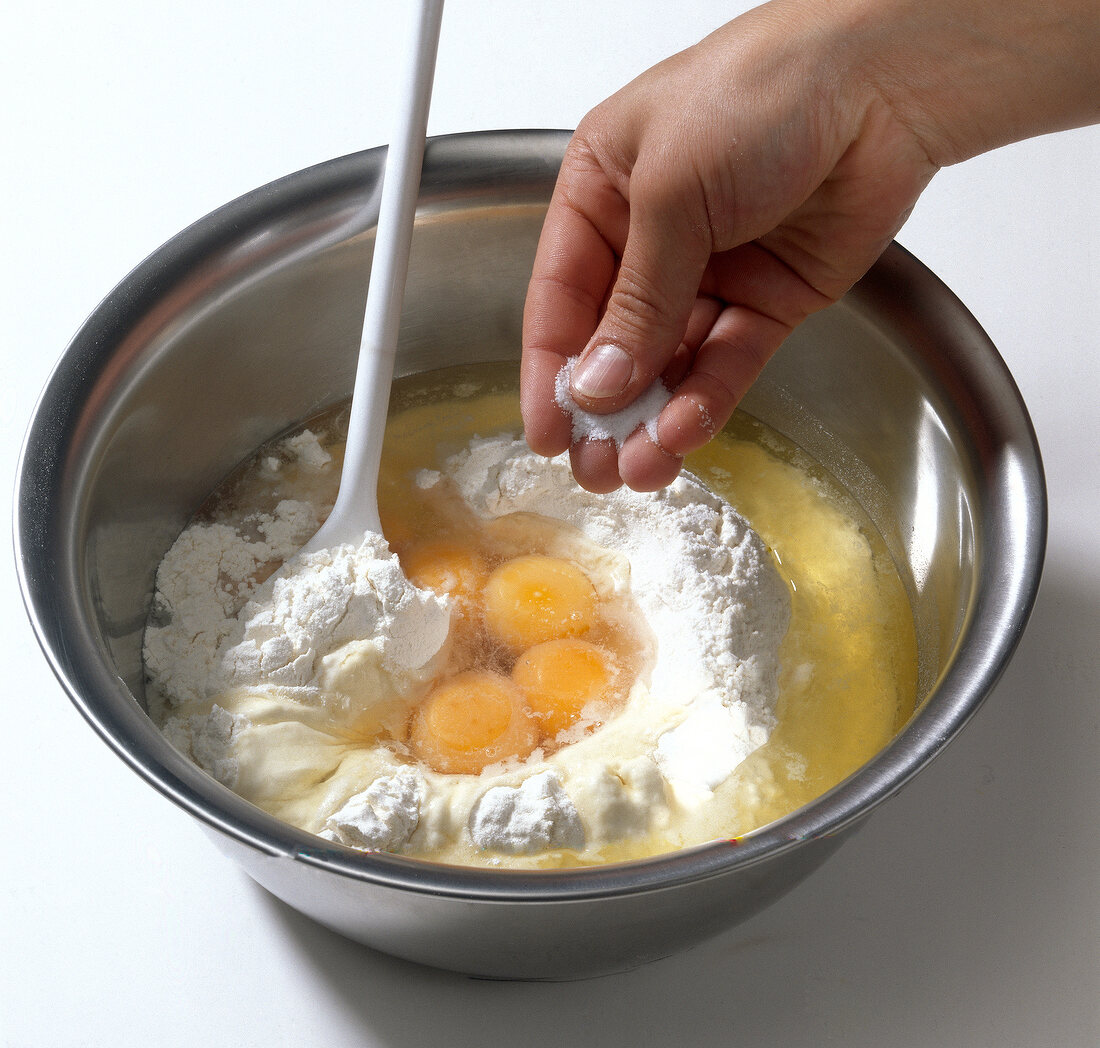 Teigwarent, Mehl und Eier in einer Schüssel, Salz zugeben