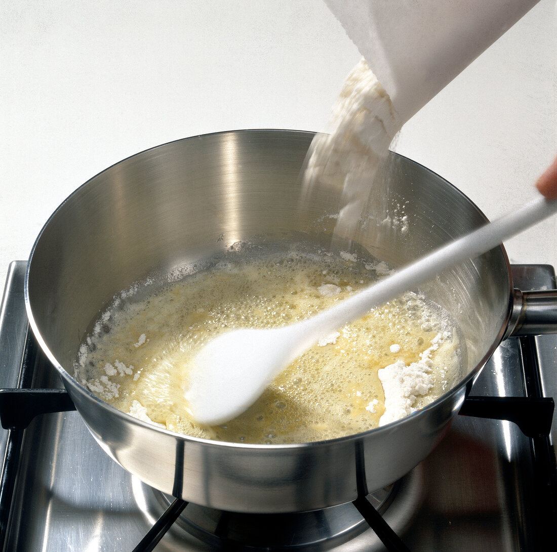Flour being added to melted butter while preparing mornay sauce, step 1
