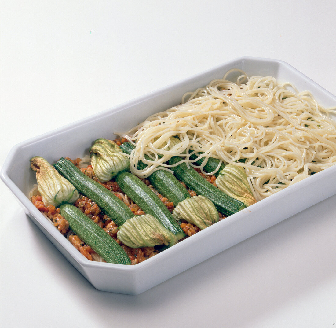Spaghetti on zucchini with sauce on tray