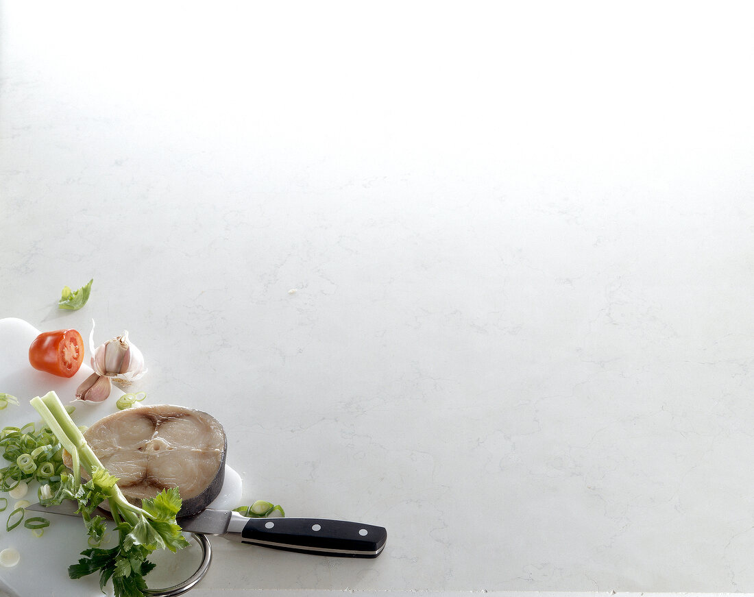 Fresh piece of swordfish, leeks and garlic on white background, copy space